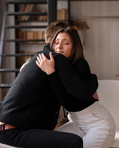 Woman hugging a man while being comforted